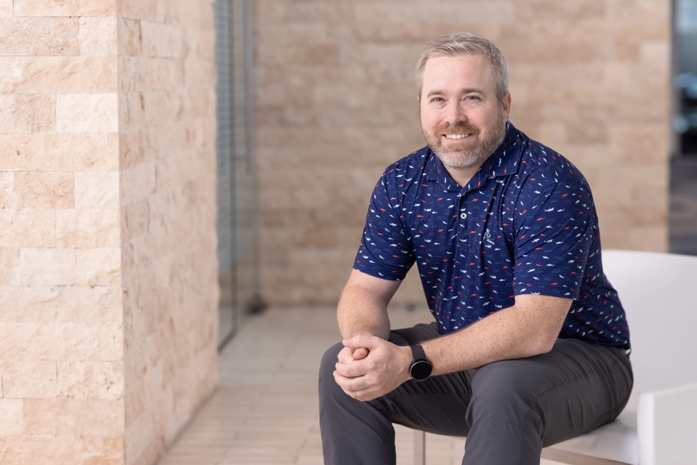 portrait of a smiling person in a collared shirt